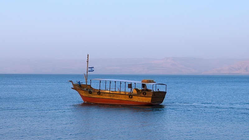 En tr�bat f�r att k�ra runt turister ute p� Gennesarets sj�, i bakgrunden skymtar kullar i diset.